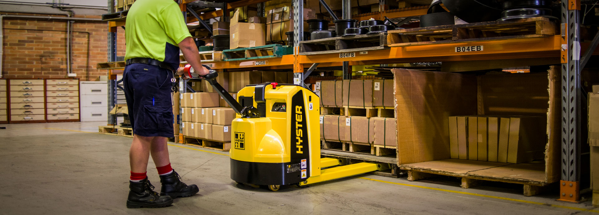 a man pushing a yellow and black machine in a warehouse
